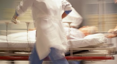 Emergency doctors rushing with patient in hospital bed